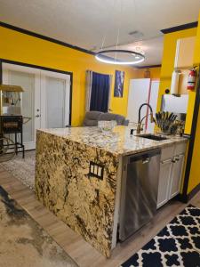 a kitchen with yellow walls and a granite counter top at Houston Sweet Spot Townhouse in Houston