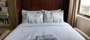 a bed with white sheets and pillows in a bedroom at Cozy33 The Persimmon Studio, Near Airport, SM, Ayala, Cebu Business Park, Cebu IT Park in Cebu City +20 photos