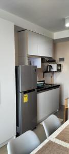 a kitchen with a stainless steel refrigerator and white cabinets at Cozy33 The Persimmon Studio, Near Airport, SM, Ayala, Cebu Business Park, Cebu IT Park in Cebu City