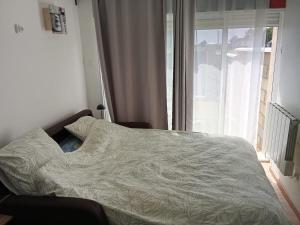 ein Bett in einem Schlafzimmer mit Fenster in der Unterkunft studio, in Doue