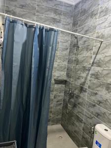 a shower with a blue shower curtain in a bathroom at Atouli Suites in Nador +29 photos