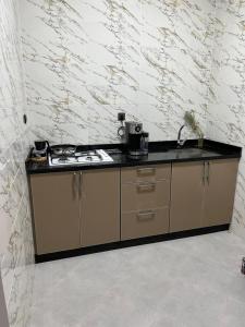 a kitchen with a stove and a counter top at Atouli Suites in Nador