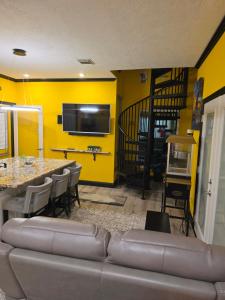 a living room with a couch and a yellow wall at Houston Sweet Spot Townhouse in Houston