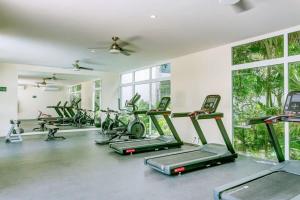 a gym with several treadmills and elliptical machines at Chic Beachfront Condo Ocean View Rooftop Pools in Akumal