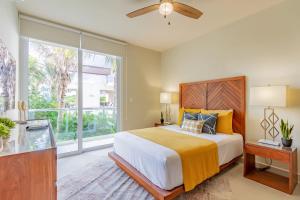 a bedroom with a bed and a large window at Chic Beachfront Condo Ocean View Rooftop Pools in Akumal