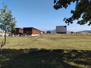 two buildings in a field with a tree at Četiri sestre in Žabljak