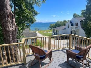 two chairs on a deck with a view of the ocean at High Tide Inn on the Ocean, Motel and Cottages in Camden
