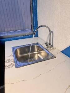 a kitchen sink with a faucet on a counter at Raiza Hotel in Concepción +11 photos