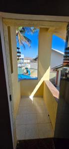 a room with a view of a pool and a window at Pousada Peruibe in Peruíbe