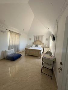 a bedroom with a bed and a chair in it at Los Patos Waterfront Private Suites in Los Patos
