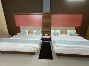 two beds in a hotel room with two bedsvisor at Athithi Bhawan in Godarpura