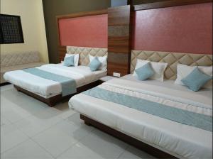 two beds in a hotel room with two beds sidx sidx at Athithi Bhawan in Godarpura