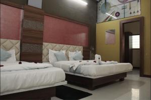 a bedroom with two beds with white sheets at Athithi Bhawan in Godarpura