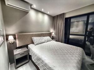 a small bedroom with a bed and a window at Studio with pool, pool table, gym and sauna in Itapema