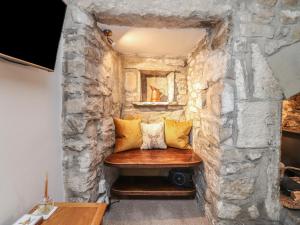 a stone walled room with a bench in the middle at Chamber End Fold in Skipton