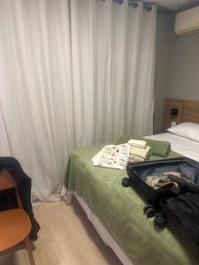a bedroom with a suitcase sitting on a bed at Zuppolini in Campina Grande