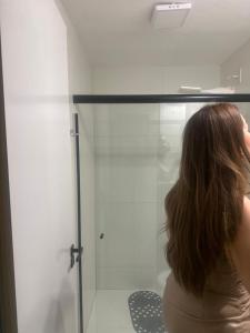 a woman is looking inside of a glass door at Zuppolini in Campina Grande