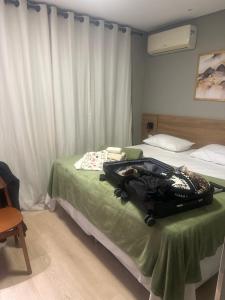 a suitcase sitting on a bed in a room at Zuppolini in Campina Grande