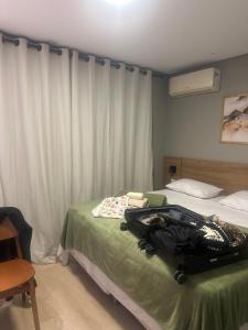 a hotel room with a suitcase on a bed at Zuppolini in Campina Grande