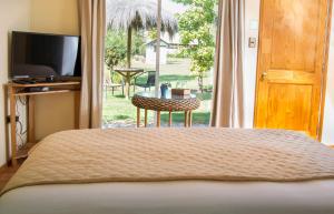 a bedroom with a bed and a television and a table at Spa Pirque & Hotel in Pirque