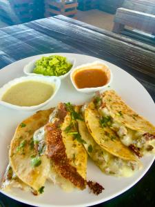 a white plate of food with omelets and sauce at The Beach Break Hotel El Cocal in Playa San Blas