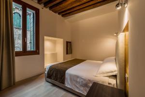 a bedroom with a bed and a window at Charming Palace Corte del Teatro in Venice +42 photos