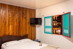a bedroom with a bed and a tv on a wall at Hotel Casa Rosario in Circasia