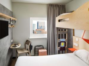 a bedroom with a bed and a desk and a window at ibis budget Birmingham Centre in Birmingham