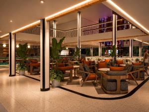 a restaurant with chairs and tables in a building at Tribe Bali Legian in Legian