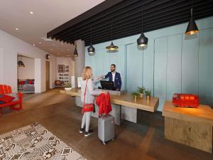 a man and a woman standing at a desk at Ibis El Jadida in El Jadida +114 photos