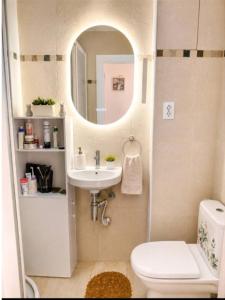 a bathroom with a sink and a toilet and a mirror at Luna house in Zaragoza
