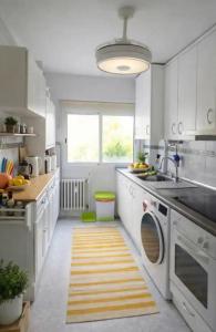 a white kitchen with a sink and a dishwasher at Luna house in Zaragoza