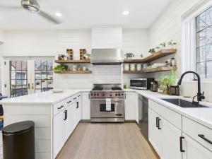 a kitchen with white cabinets and stainless steel appliances at Luxe Chicago Retreat Game Room, Deck Fire Pit in Chicago