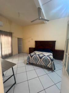 a bedroom with a bed and a ceiling fan at Las Brisas House, Manzanillo in Manzanillo