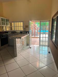 a kitchen with a tile floor and an open door at Las Brisas House, Manzanillo in Manzanillo