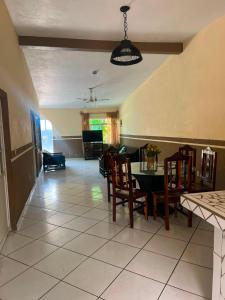 a dining room and living room with a table and chairs at Las Brisas House, Manzanillo in Manzanillo