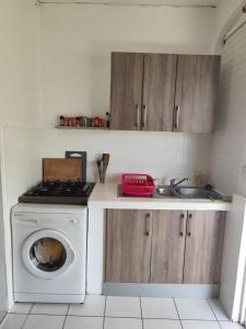 a kitchen with a washing machine and a sink at Studio spacieux au calme in Capesterre