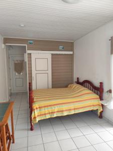 a bedroom with a bed in a white room at Studio spacieux au calme in Capesterre