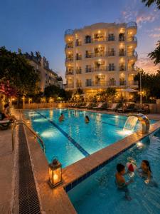 a large swimming pool with people in a hotel at Antalya Premium Resort in Antalya