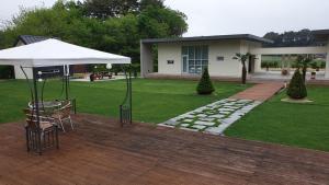 a patio with a table and an umbrella and a house at Gangneung Thebrillant in Gangneung +7 photos