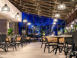 a dining room with tables and chairs and lights at Sofitel Dubai Jumeirah Beach in Dubai +90 photos