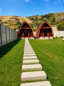 a stone path in front of two huts at Wavez Bungalow in Selong Belanak