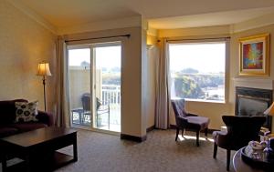 a living room with a couch and chairs and a fireplace at North Cliff Hotel in Fort Bragg