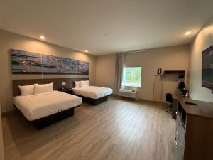 a hotel room with two beds and a flat screen tv at Clarion Pointe Port Lavaca in Port Lavaca