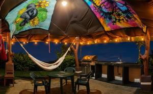 a hammock in a tent with a table and a grill at Hills Villa Rio Celeste in Rio Celeste