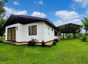 a small white house with a black roof at Hills Villa Rio Celeste in Rio Celeste