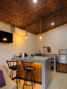 a kitchen with a counter and two bar stools at Hills Villa Rio Celeste in Rio Celeste +27 photos