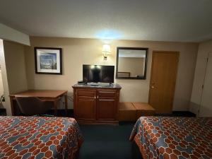 a hotel room with two beds and a desk and a mirror at America's Best Inn & Suites Eureka in Eureka