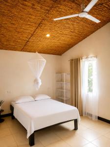 a bedroom with a white bed and a ceiling at Hills Villa Rio Celeste in Rio Celeste