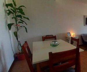 a table and chairs with a plant in a room at Cabaña con balcón luminosa in Ushuaia